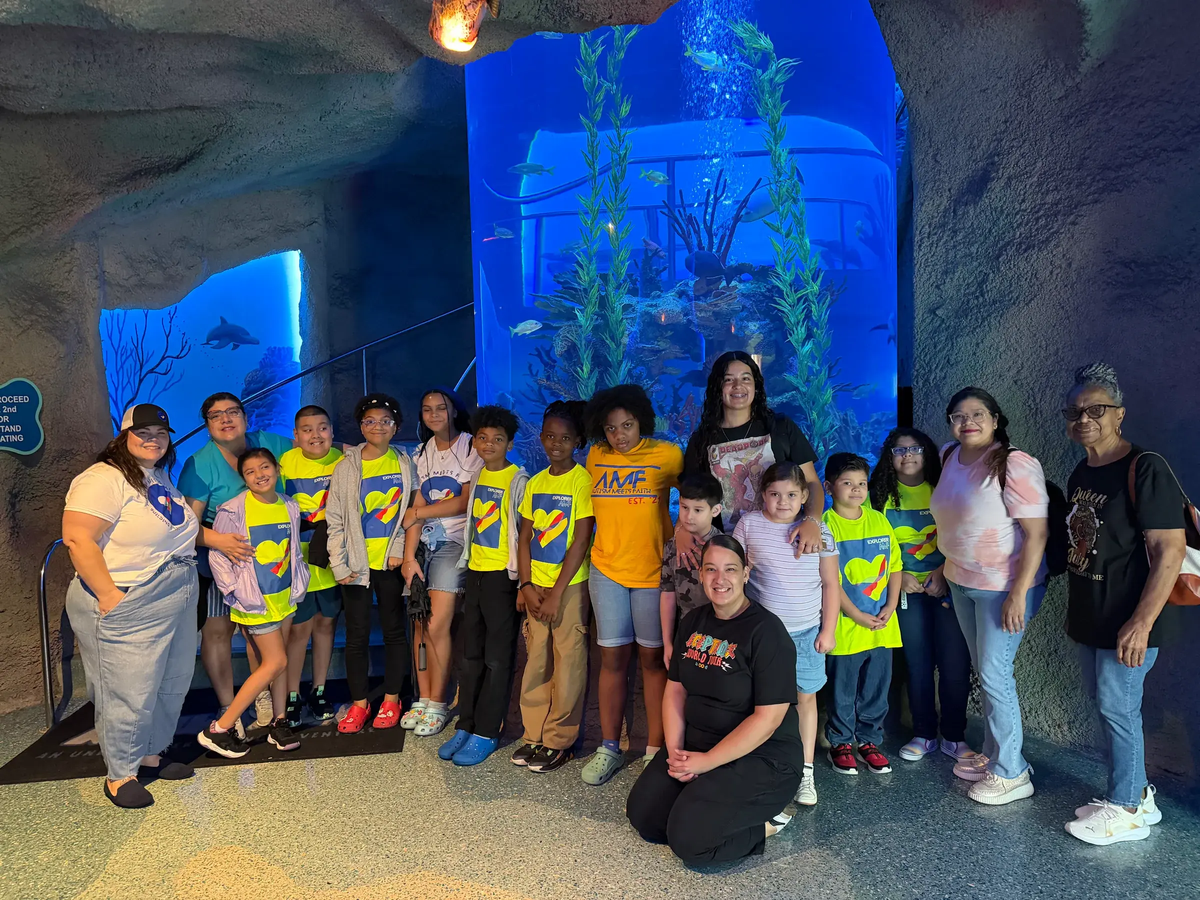 AMF participants pose together in front of an aquarium exhibit.