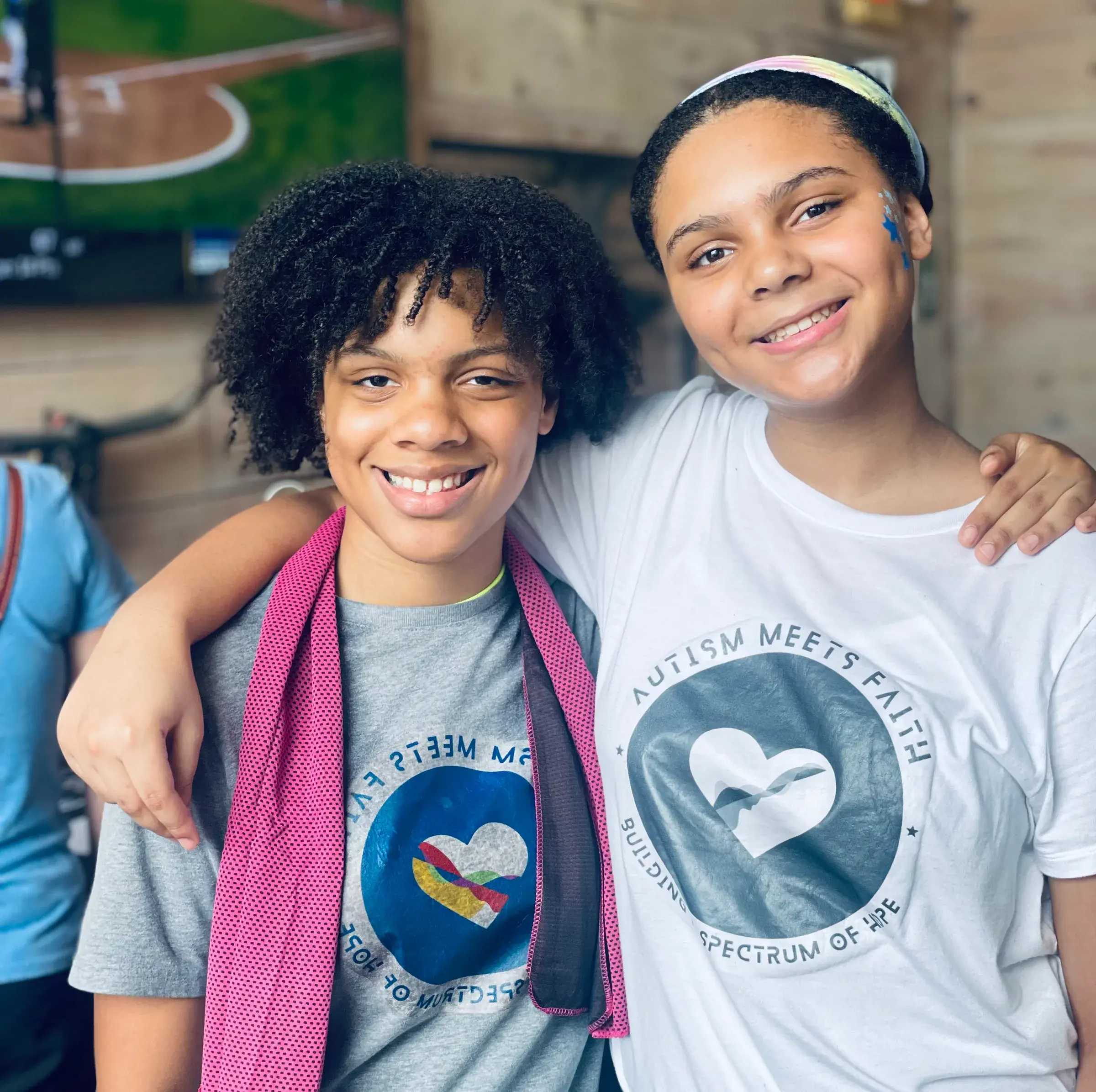 Two young people smile side by side in AMF shirts.